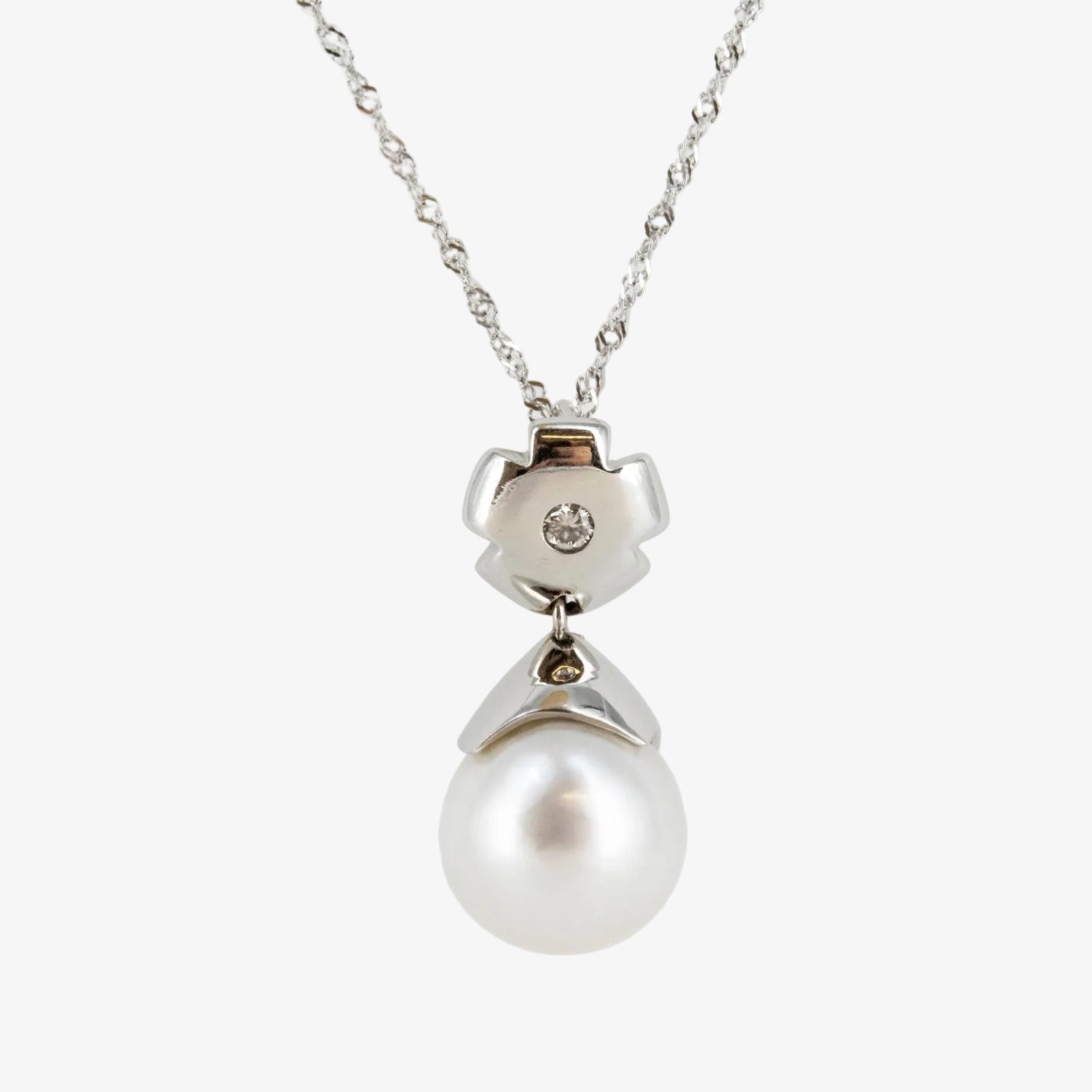 Colgante de oro blanco de 18 kt. con perla australiana de 12 mm. y diamante talla brillante
