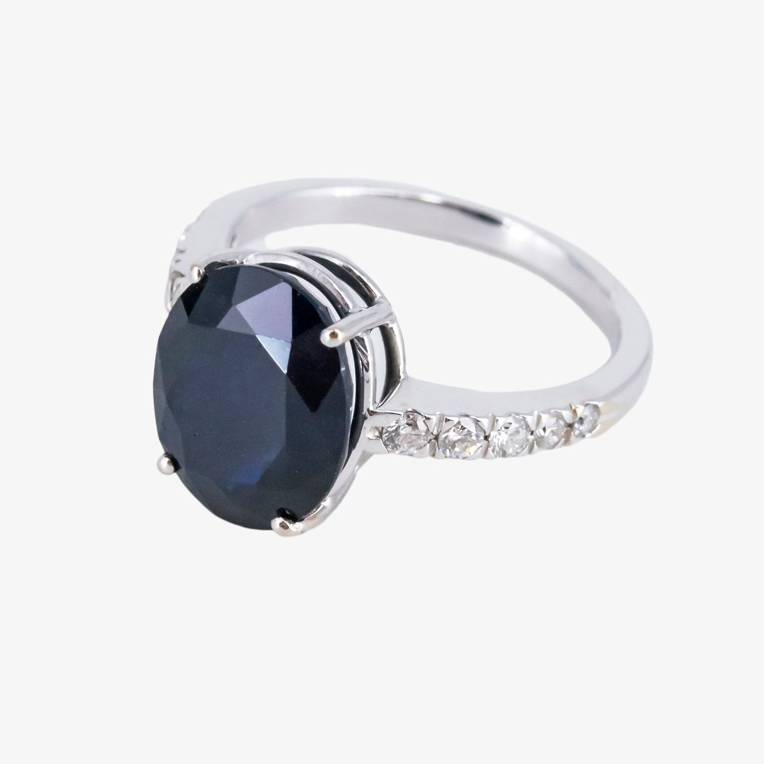 Sortija de oro blanco 18 kt. con zafiro de talla oval y diamantes talla brillante