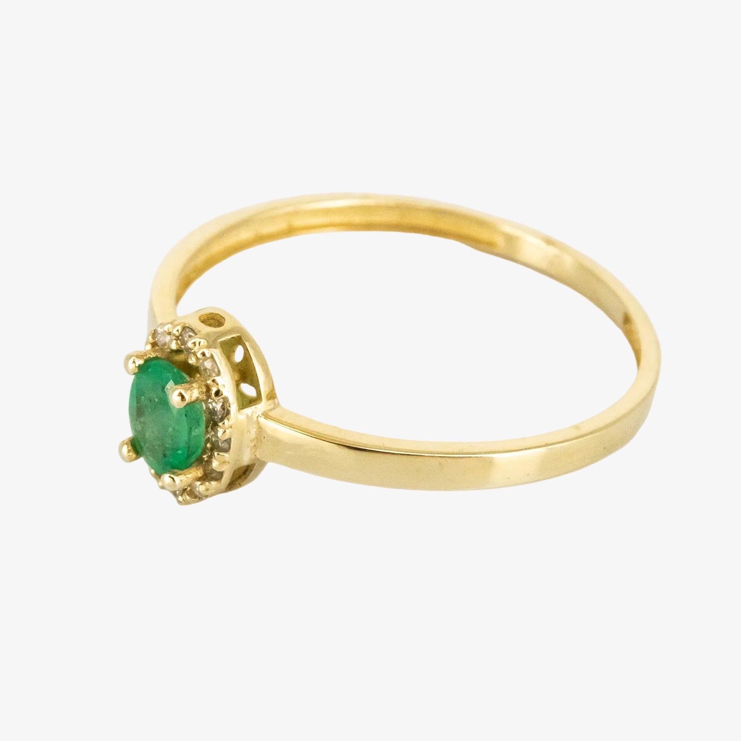 Sortija de oro amarillo de 14 kt. con doce diamantes y una esmeralda de 0.30 ct.