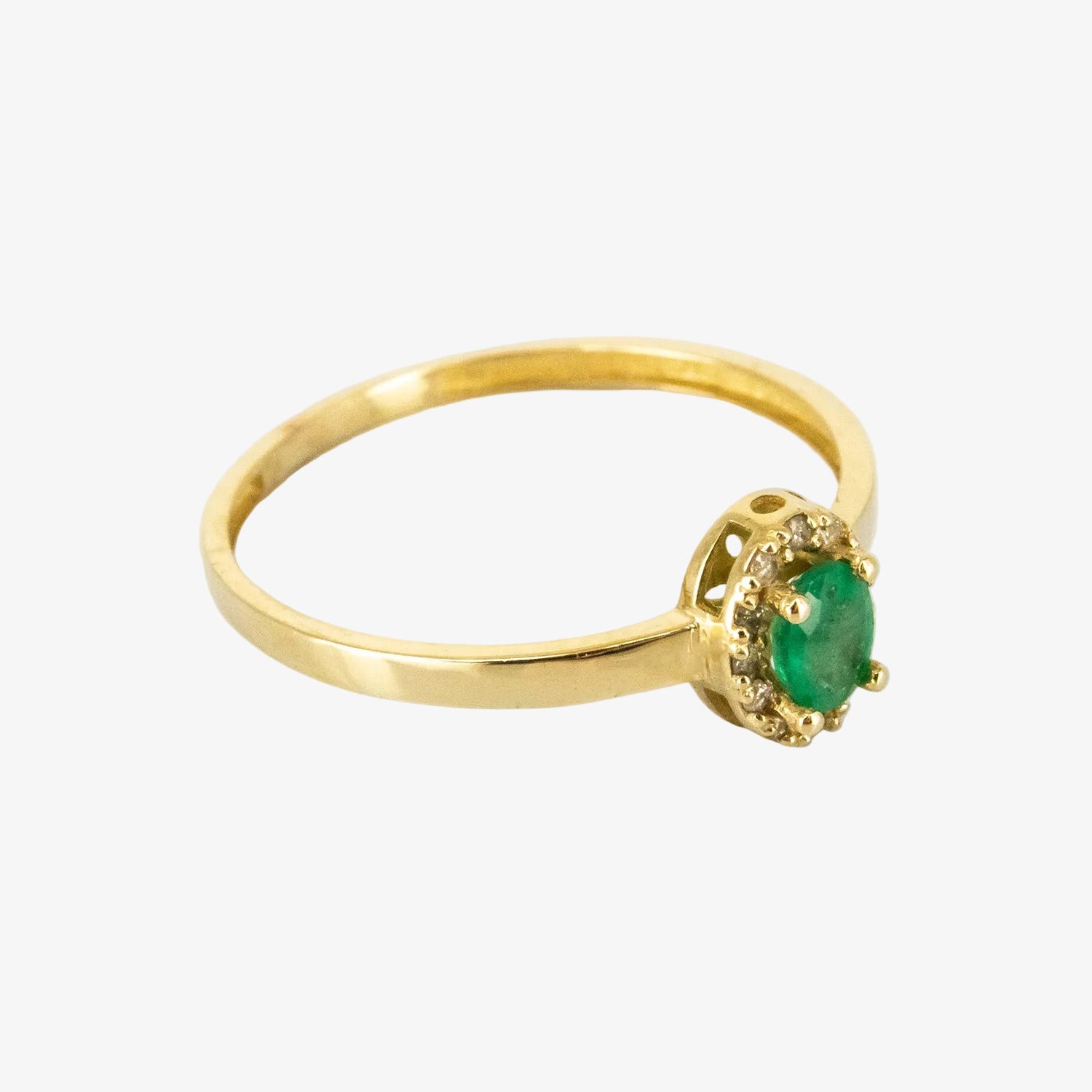 Sortija de oro amarillo de 14 kt. con doce diamantes y una esmeralda de 0.30 ct.