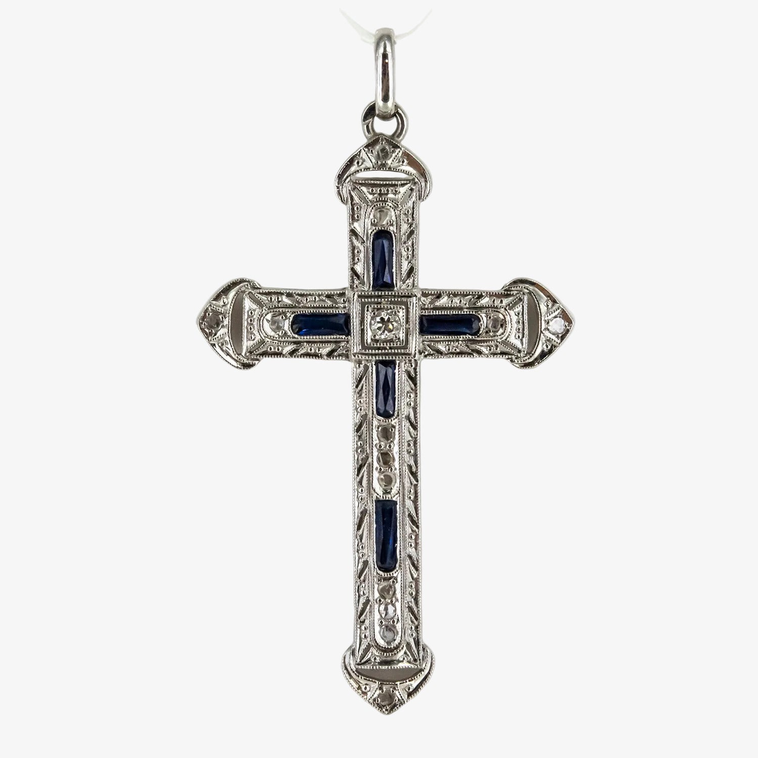 Colgante cruz de oro blanco 18 kt. con diamantes y zafiros