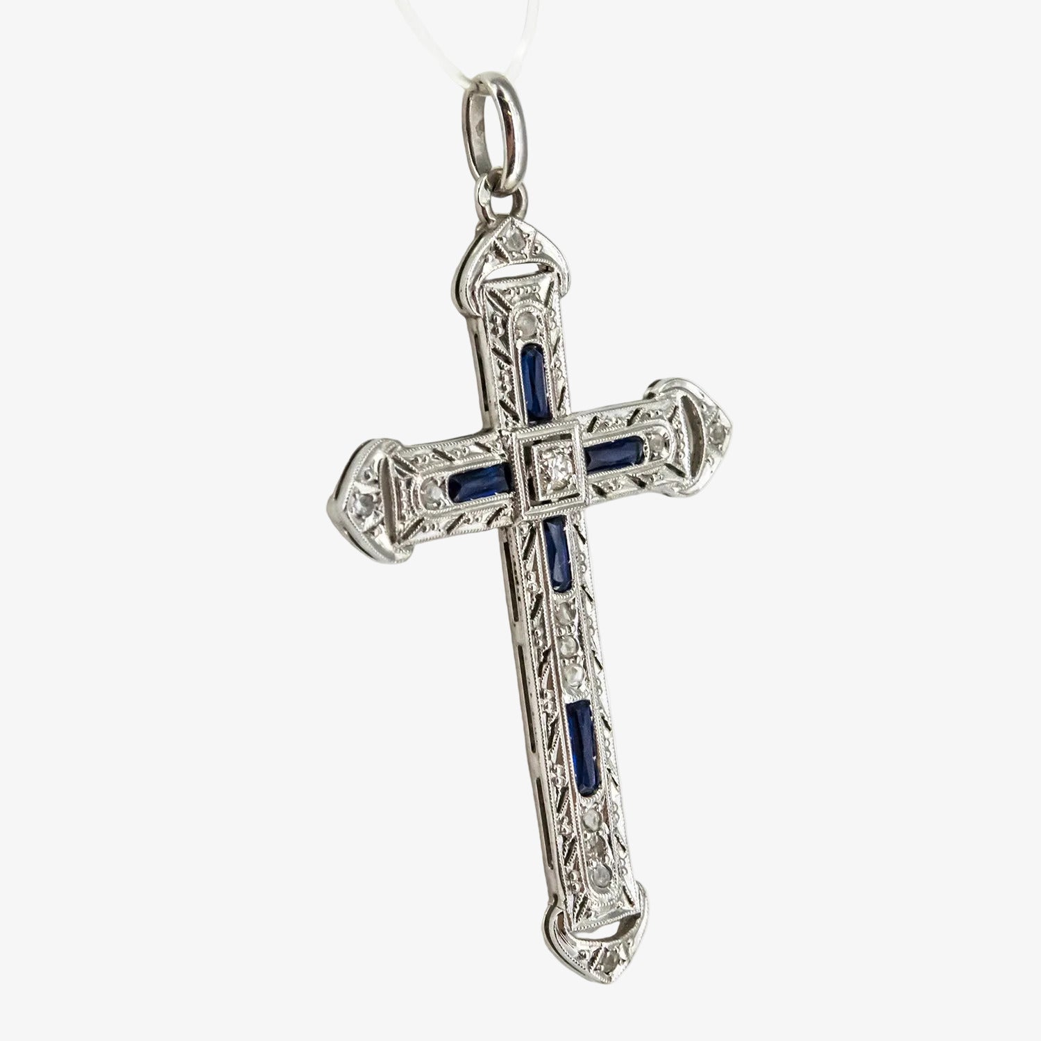 Colgante cruz de oro blanco 18 kt. con diamantes y zafiros