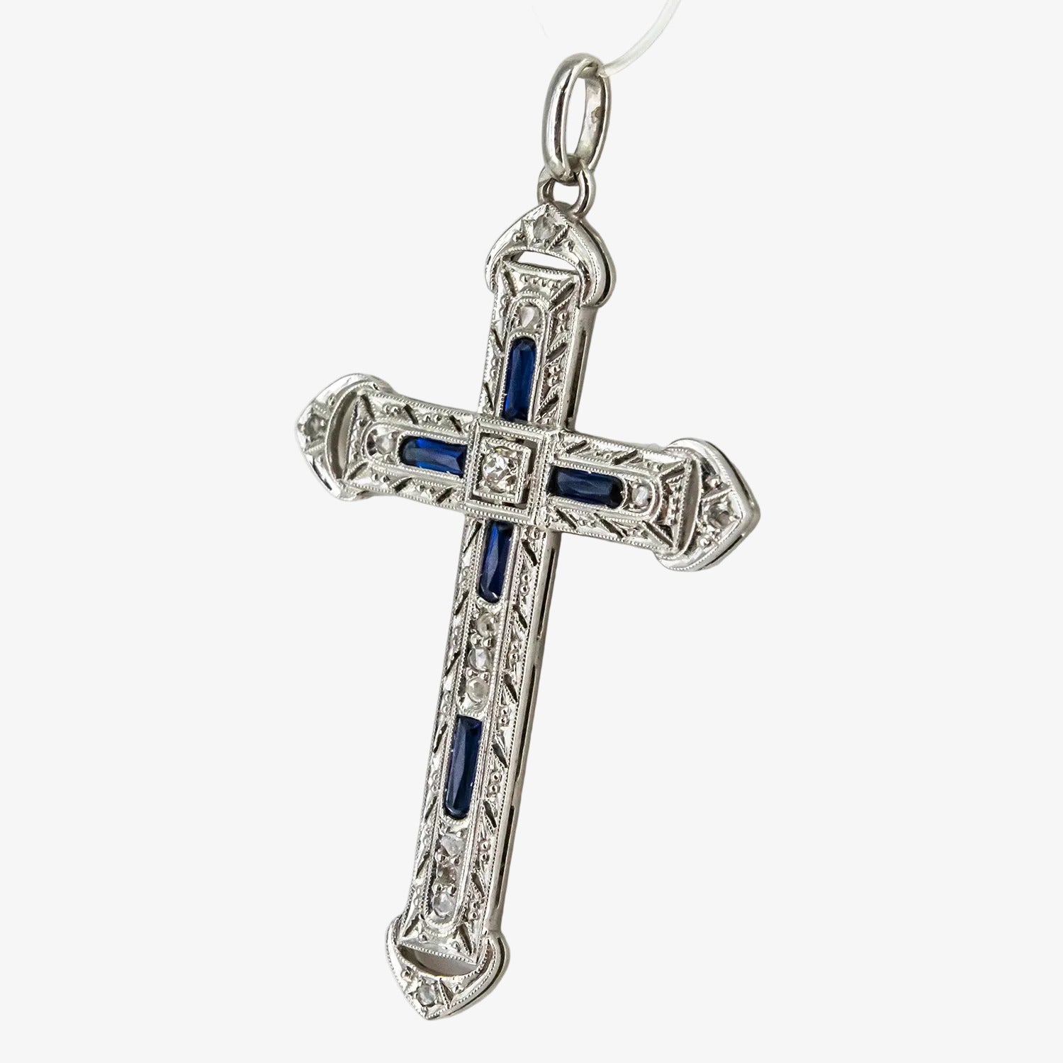 Colgante cruz de oro blanco 18 kt. con diamantes y zafiros