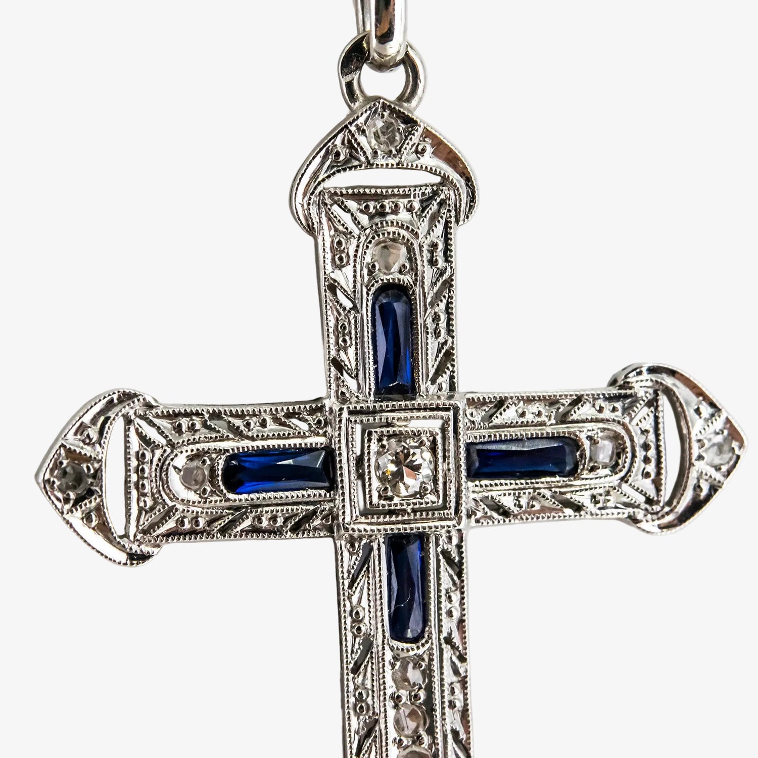 Colgante cruz de oro blanco 18 kt. con diamantes y zafiros