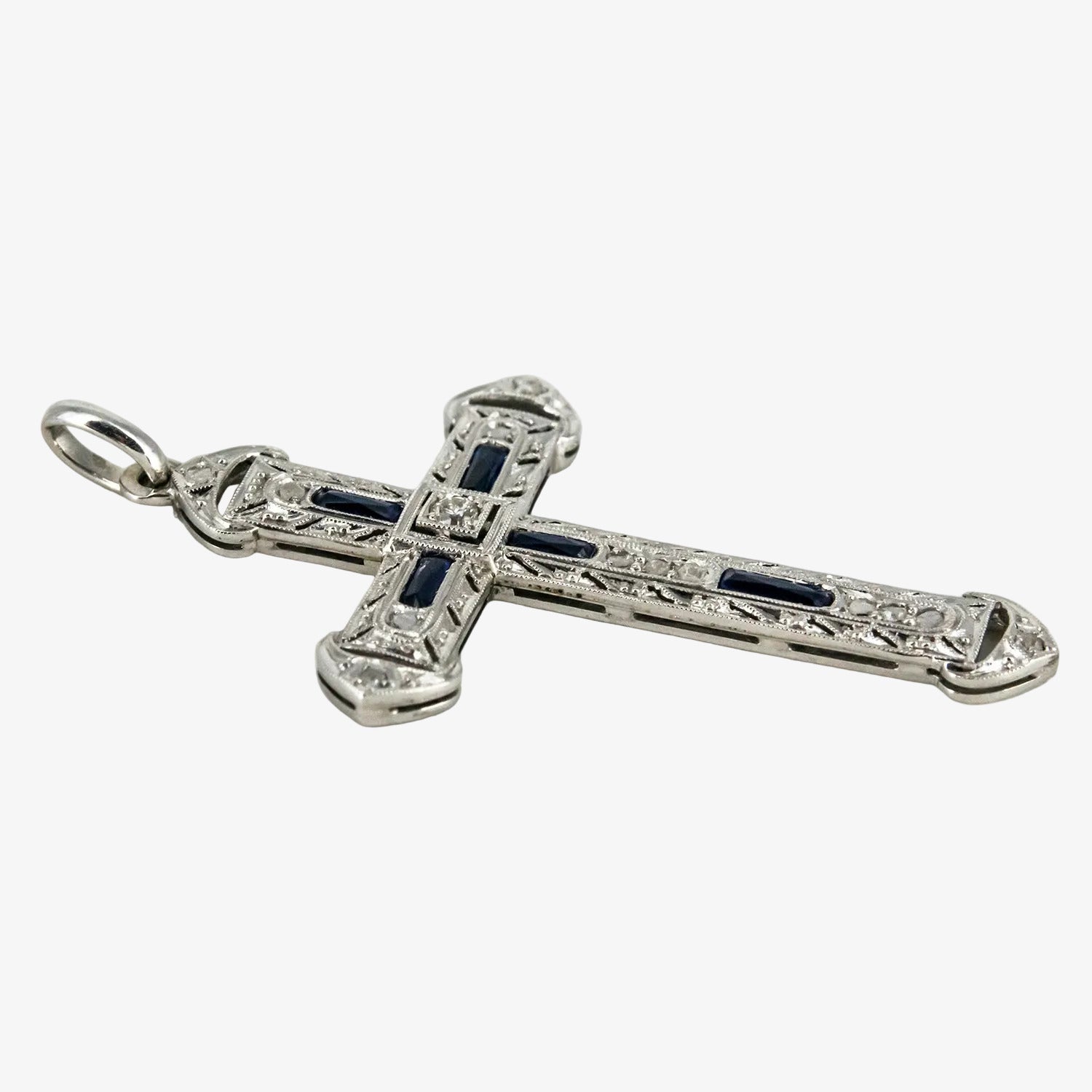 Colgante cruz de oro blanco 18 kt. con diamantes y zafiros