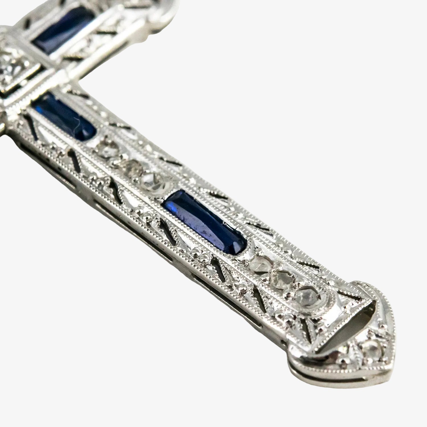 Colgante cruz de oro blanco 18 kt. con diamantes y zafiros
