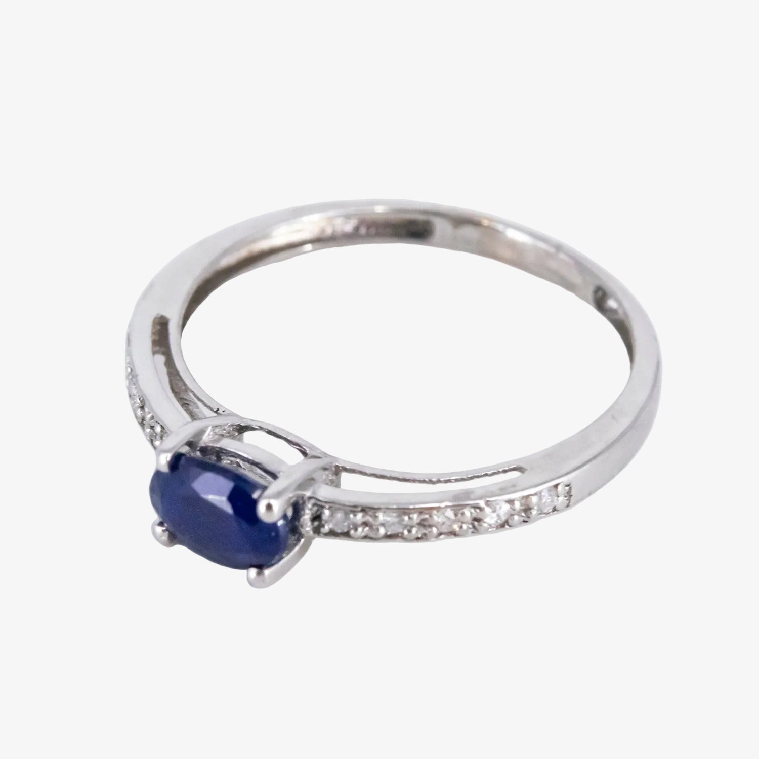 Sortija de oro blanco de 18 kt. con diamantes y un zafiro central