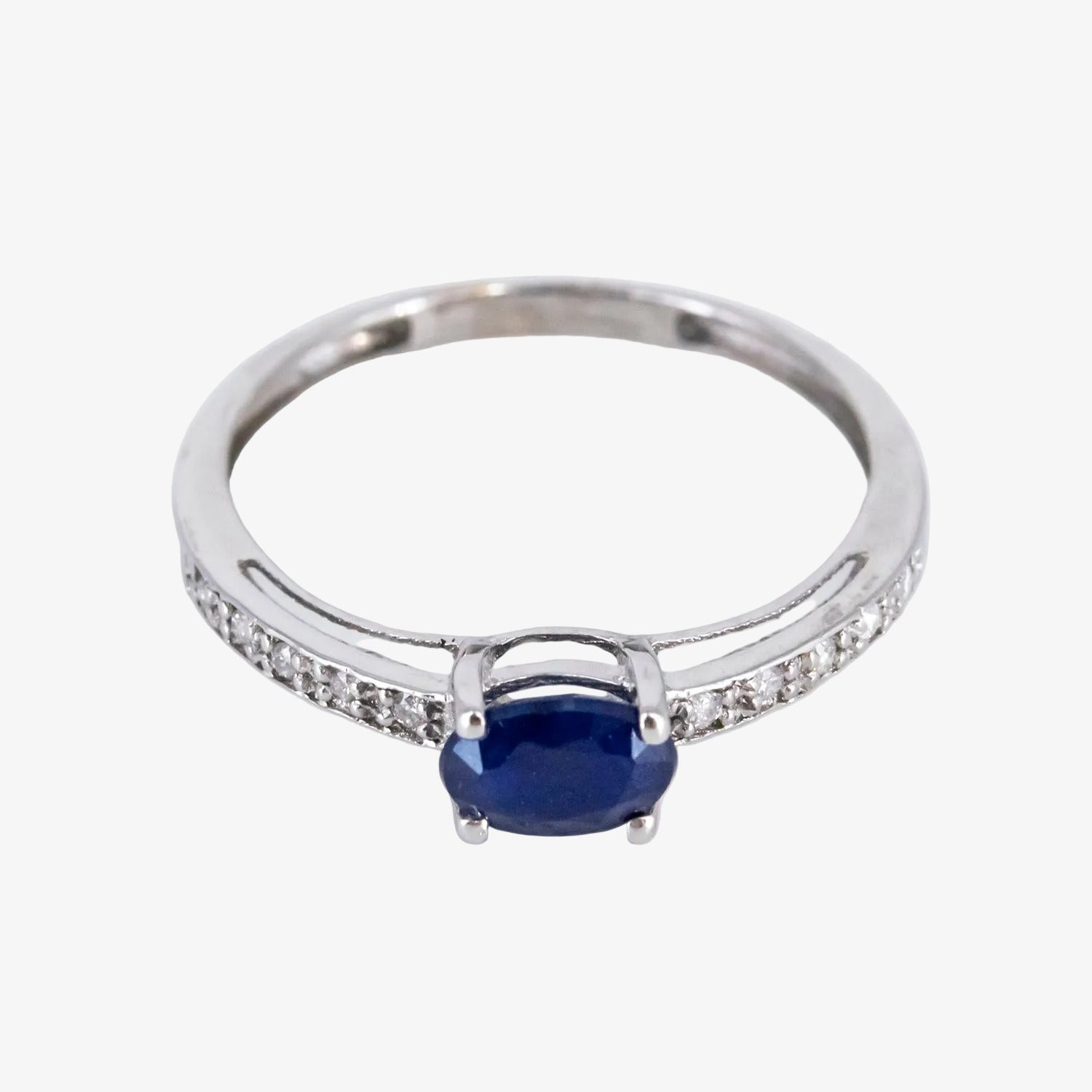 Sortija de oro blanco de 18 kt. con diamantes y un zafiro central