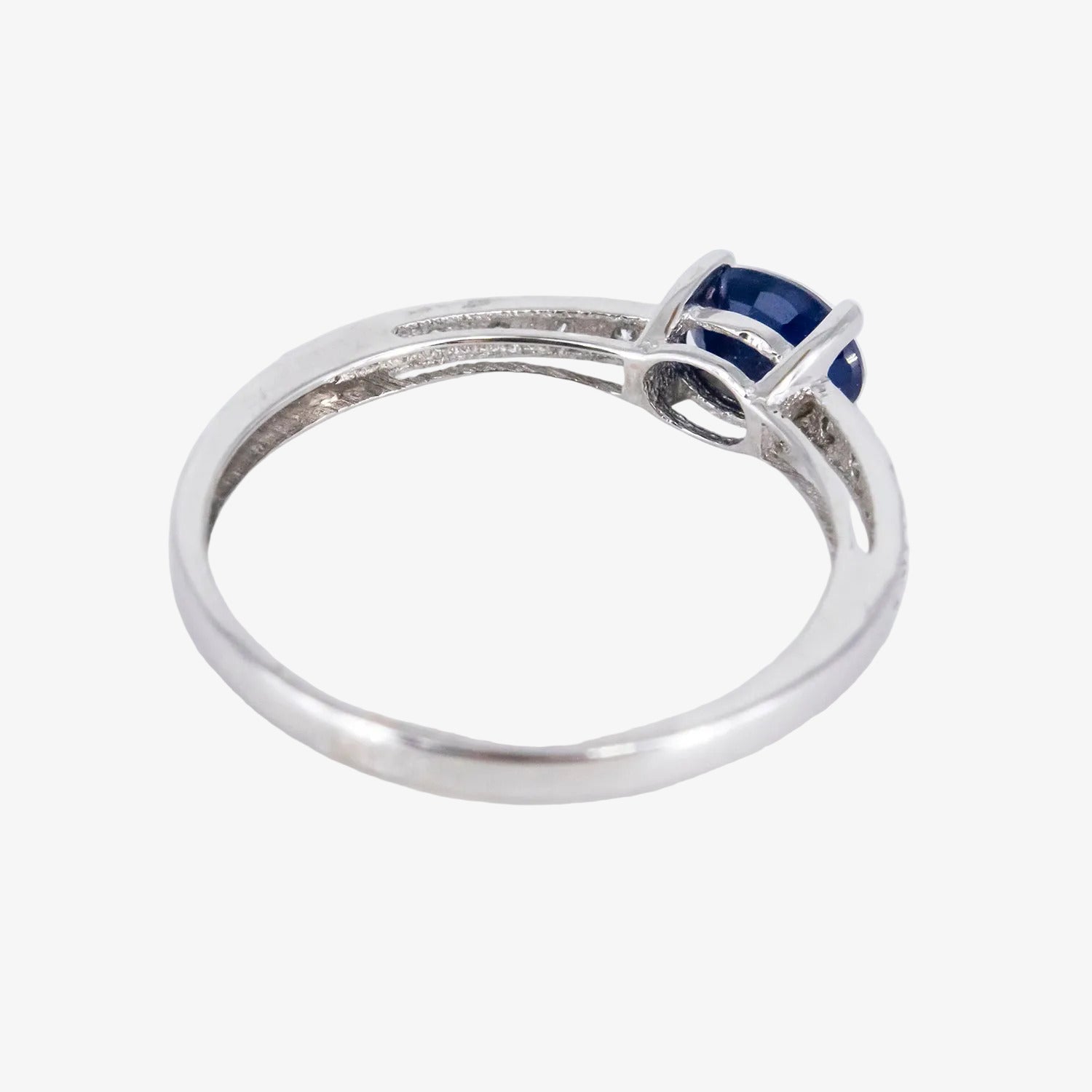 Sortija de oro blanco de 18 kt. con diamantes y un zafiro central