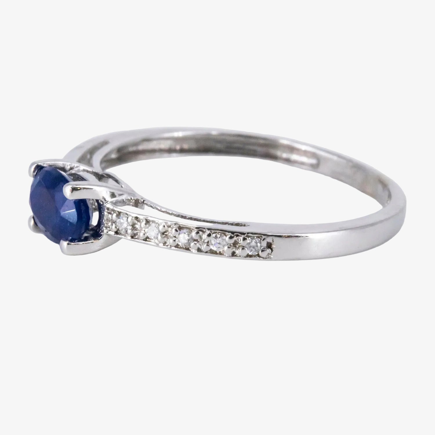 Sortija de oro blanco de 18 kt. con diamantes y un zafiro central