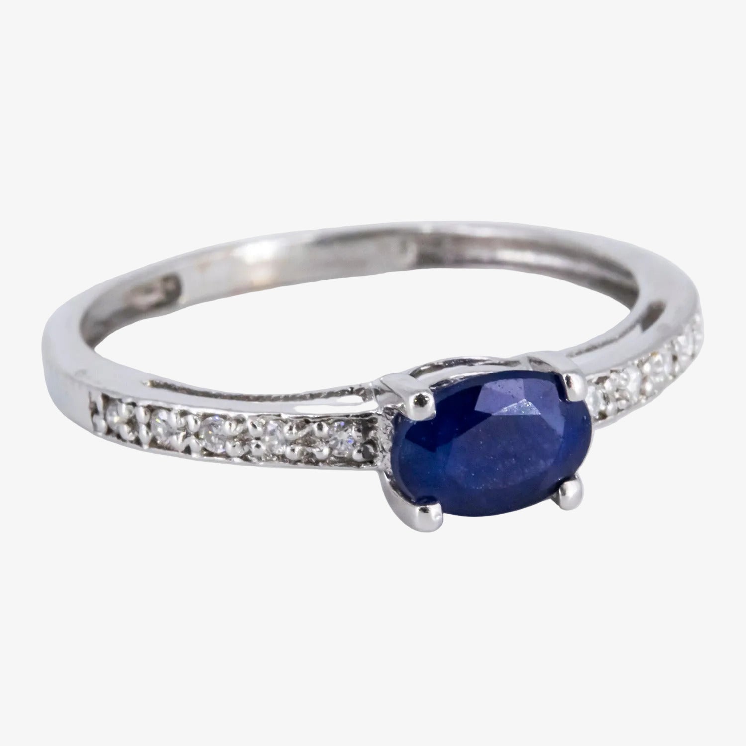 Sortija de oro blanco de 18 kt. con diamantes y un zafiro central