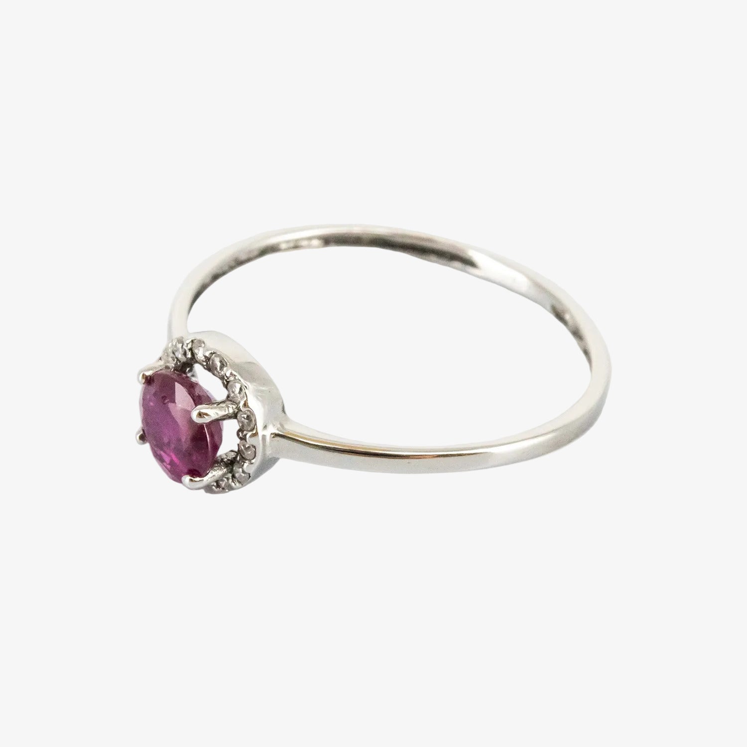 Sortija de oro blanco 18 kt. con un rubí de 0.40 ct. y catorce diamantes talla brillante